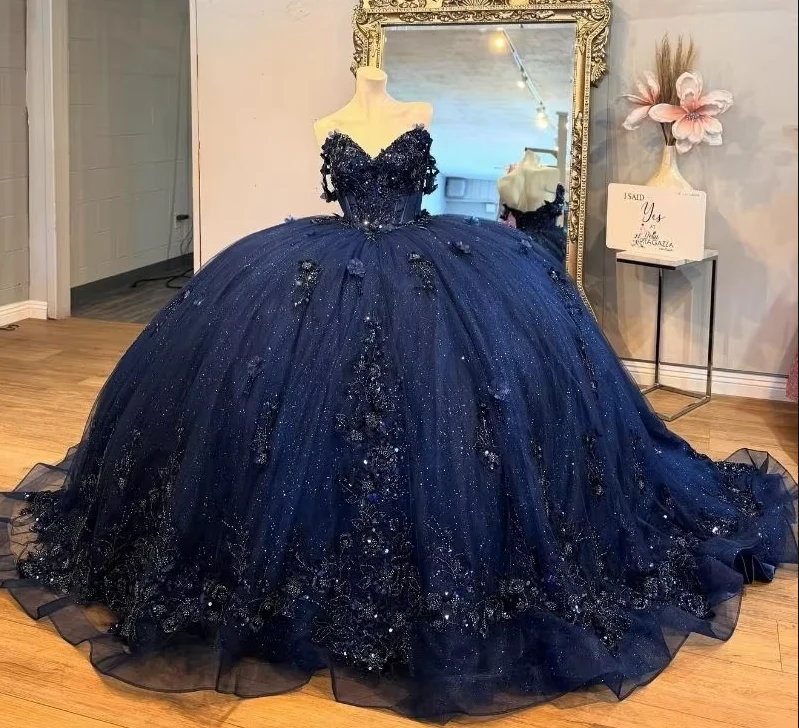 Robe de bal bleu marine pour quinceañera, ornée d'appliqués floraux et d'un corset en cristal perlé.