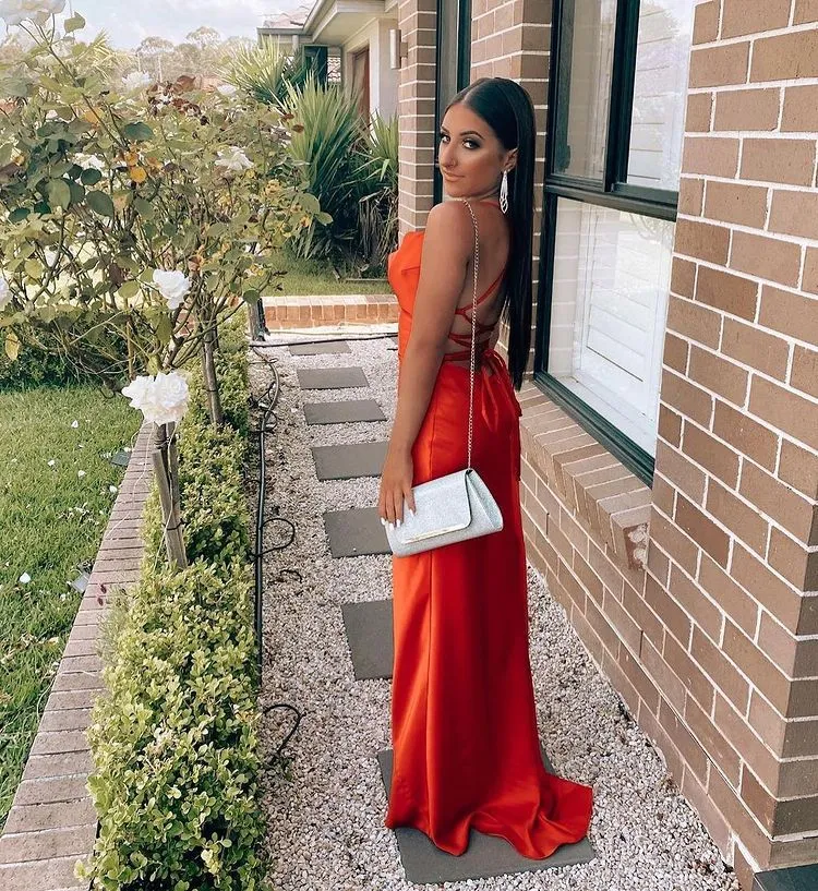 Robe de soirée rouge satinée à fines bretelles et fente haute