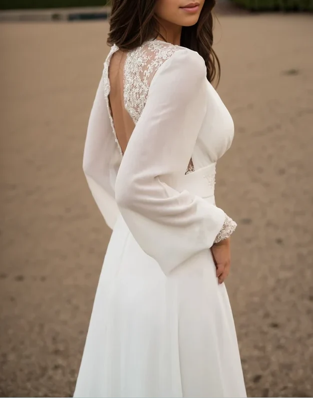 Robe de mariée en mousseline de soie à manches longues et dentelle ivoire avec traîne boutonnée dans le dos