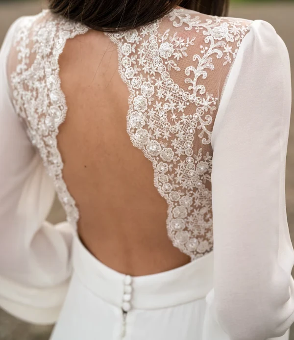 Robe de mariée en mousseline de soie à manches longues et dentelle ivoire avec traîne boutonnée dans le dos