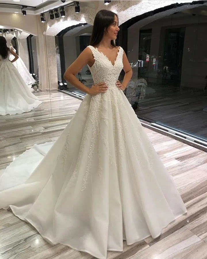 Robe de mariée élégante en dentelle, coupe trapèze, col en V, sans manches, longue, avec traîne