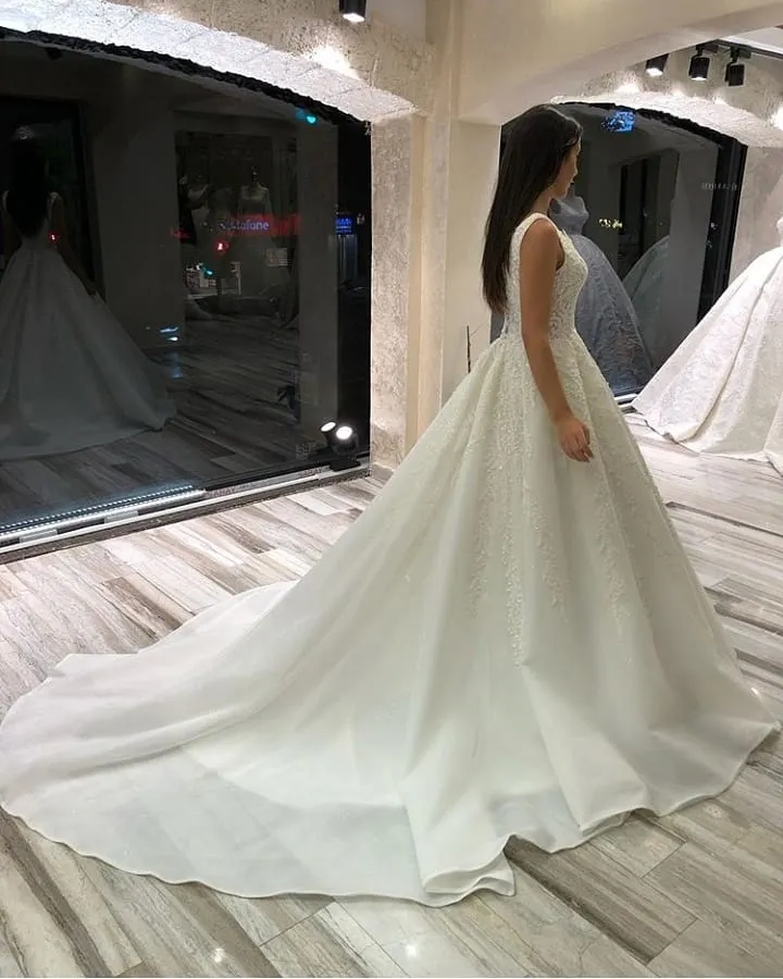 Robe de mariée élégante en dentelle, coupe trapèze, col en V, sans manches, longue, avec traîne