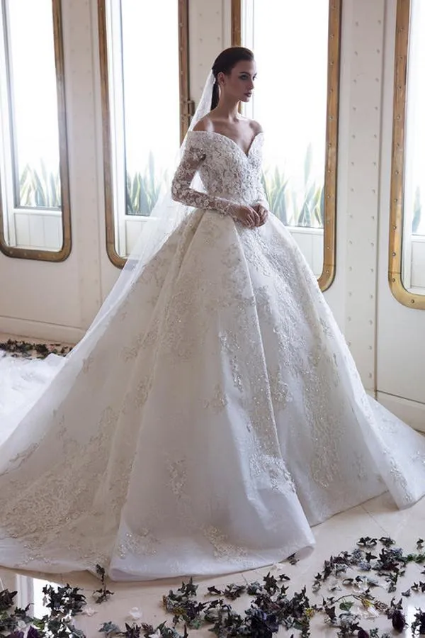 Robe de mariée élégante à épaules dénudées, coupe trapèze, manches longues, dentelle et applications en cristal