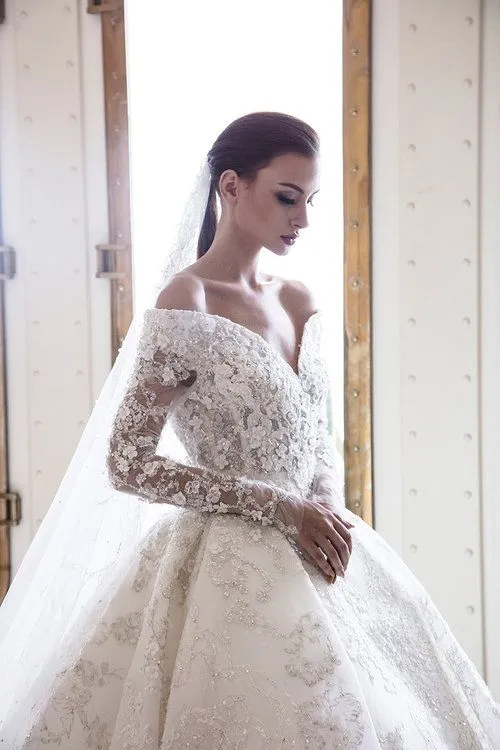 Robe de mariée élégante à épaules dénudées, coupe trapèze, manches longues, dentelle et applications en cristal