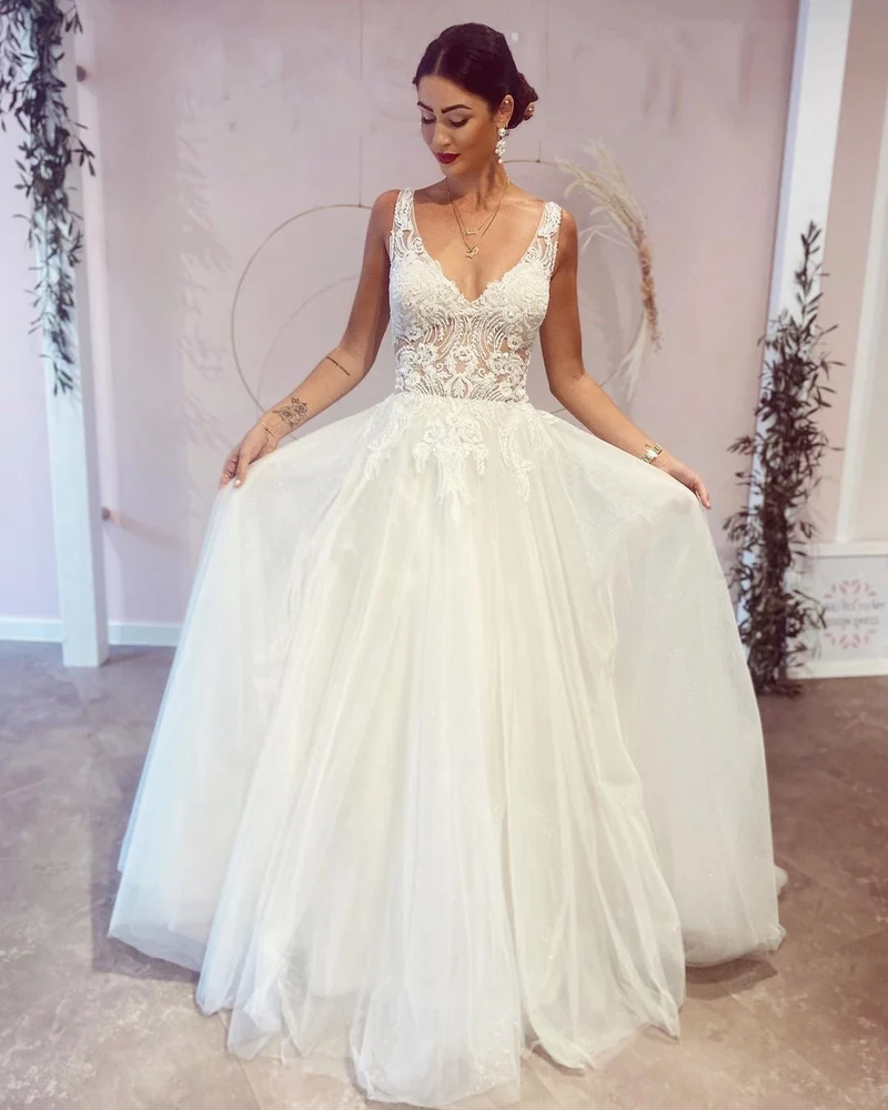 Robe de mariée élégante coupe trapèze, décolleté en V profond et dos nu, avec appliques en dentelle
