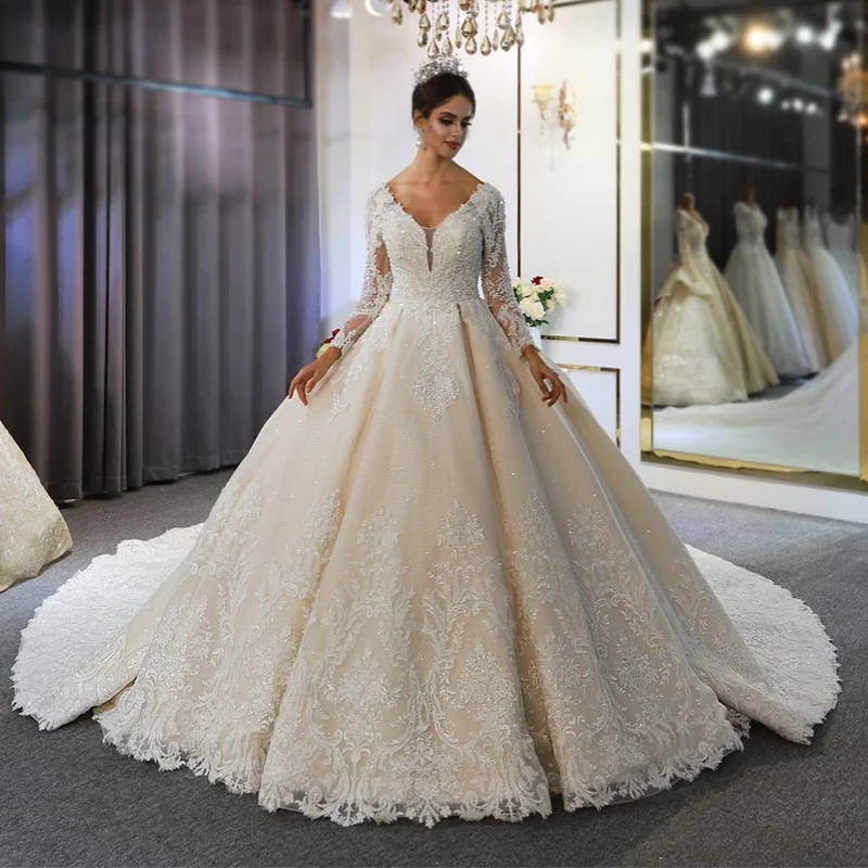 Robe de mariée élégante coupe trapèze, manches longues, appliqués en dentelle et paillettes