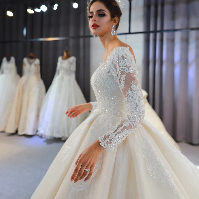 Robe de mariée élégante coupe trapèze, manches longues, appliqués en dentelle et paillettes