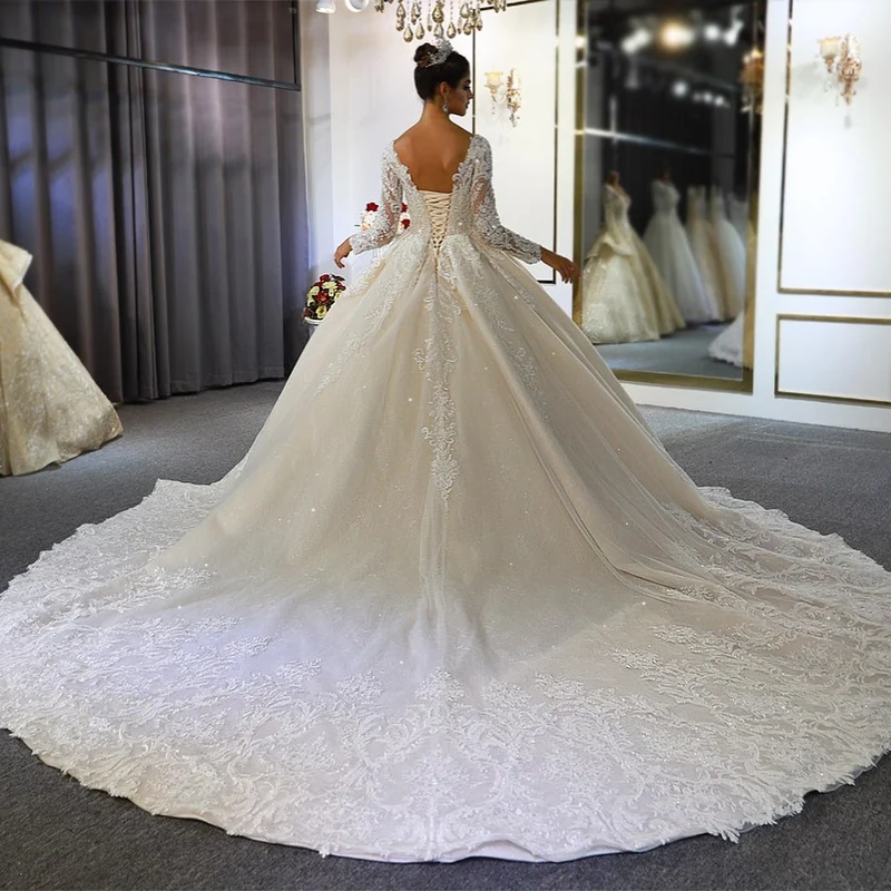 Robe de mariée élégante coupe trapèze, manches longues, appliqués en dentelle et paillettes