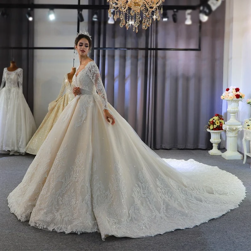 Robe de mariée élégante coupe trapèze, manches longues, appliqués en dentelle et paillettes