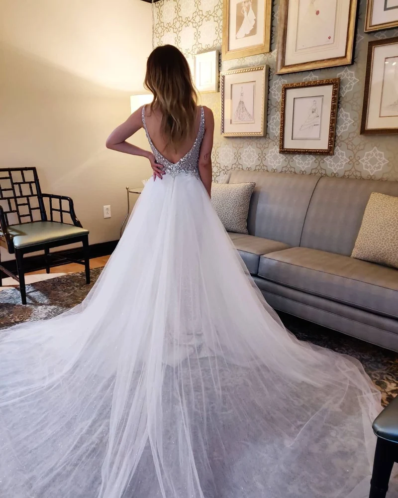 Robe de mariée élégante en tulle sans manches, col en V, dos nu et traîne chapelle