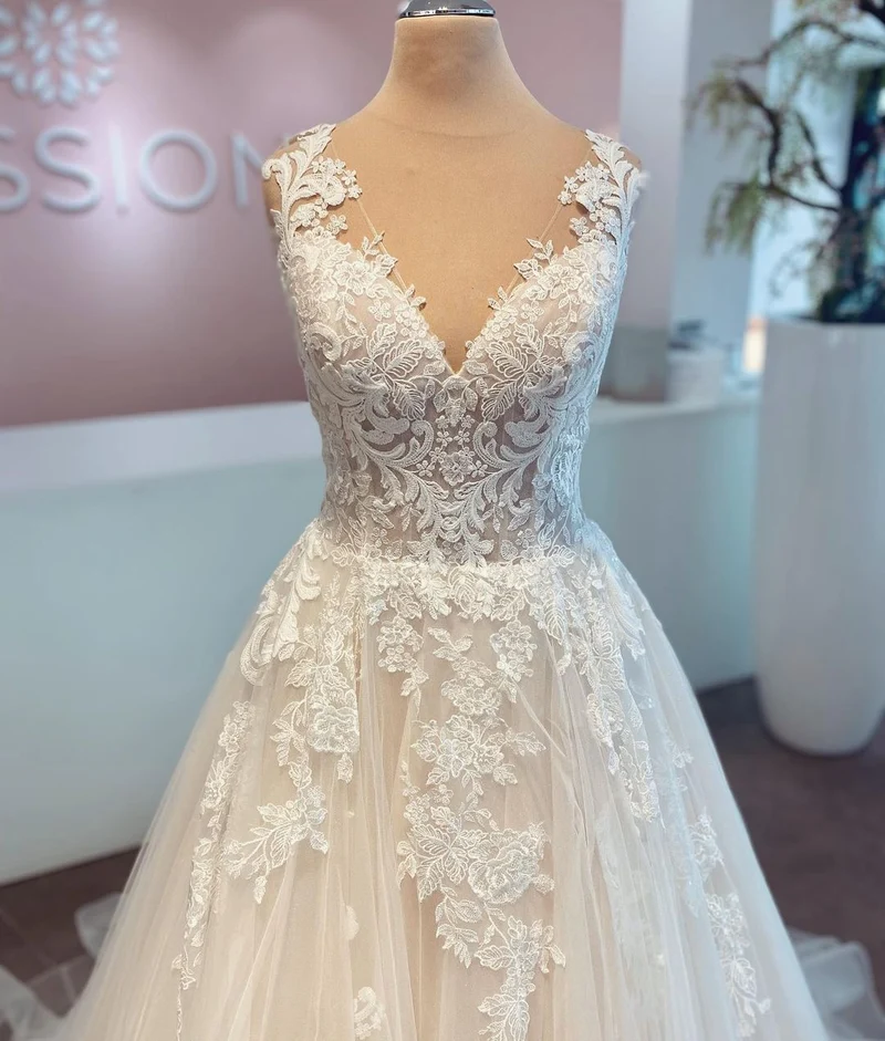Robe de mariée élégante en dentelle et tulle, coupe trapèze, col en V, sans manches