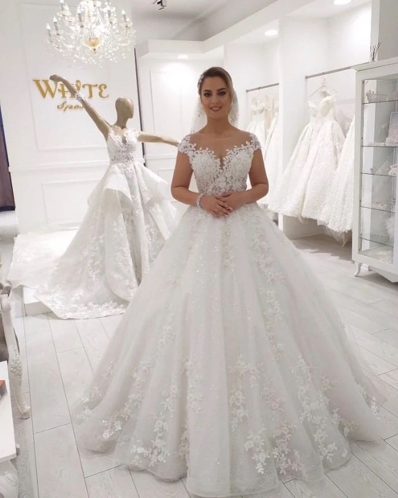 Robe de mariée élégante coupe trapèze sans manches avec appliques en dentelle et volants