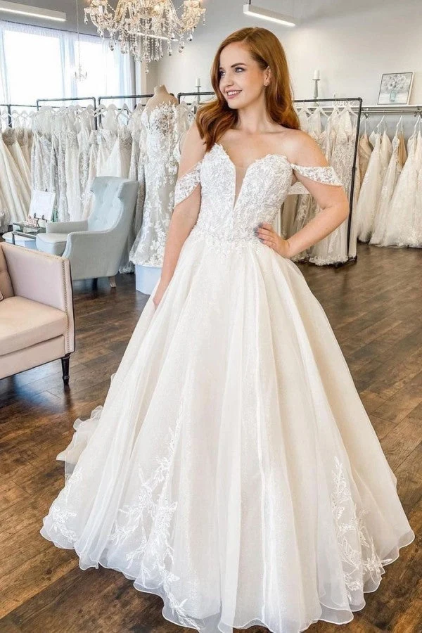 Robe de mariée décolletée en cœur avec traîne, dos nu, coupe trapèze, appliques en dentelle