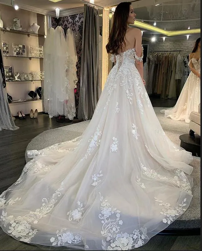 Robe de mariée trapèze à décolleté en V profond et dos nu, manches longues, appliques en perles et dentelle