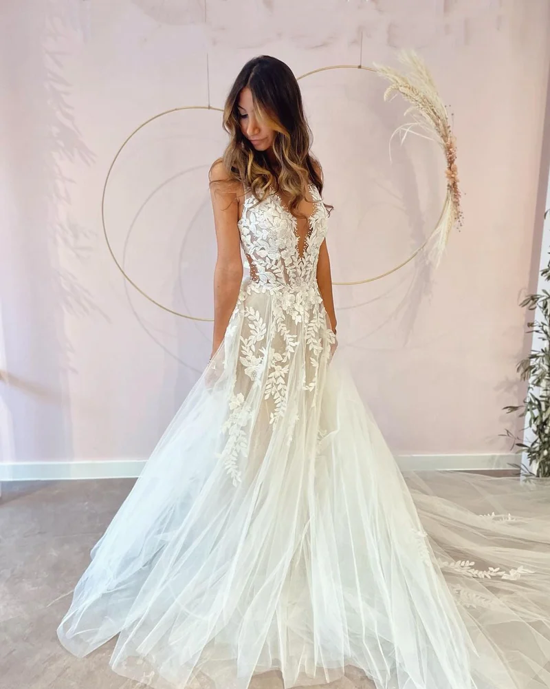 Robe de mariée élégante coupe trapèze, décolleté en V profond et dos nu, avec appliques en dentelle