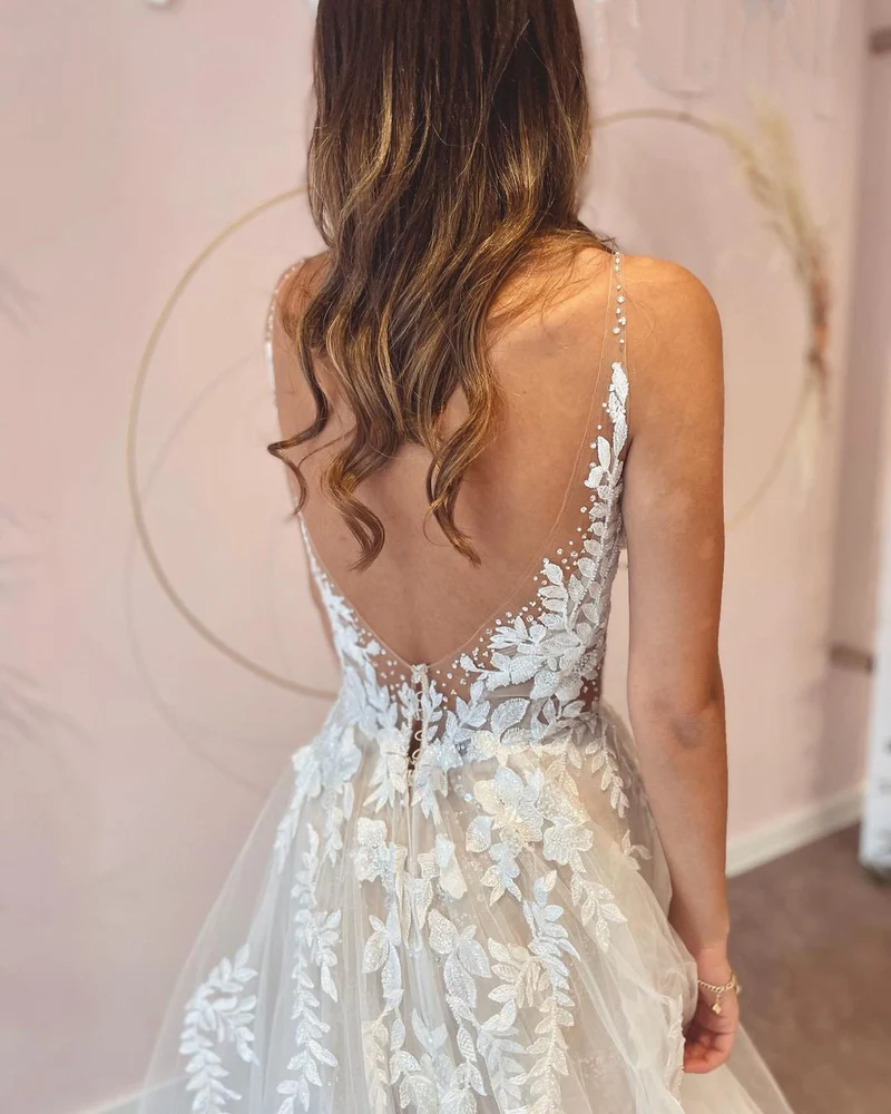 Robe de mariée élégante coupe trapèze, décolleté en V profond et dos nu, avec appliques en dentelle
