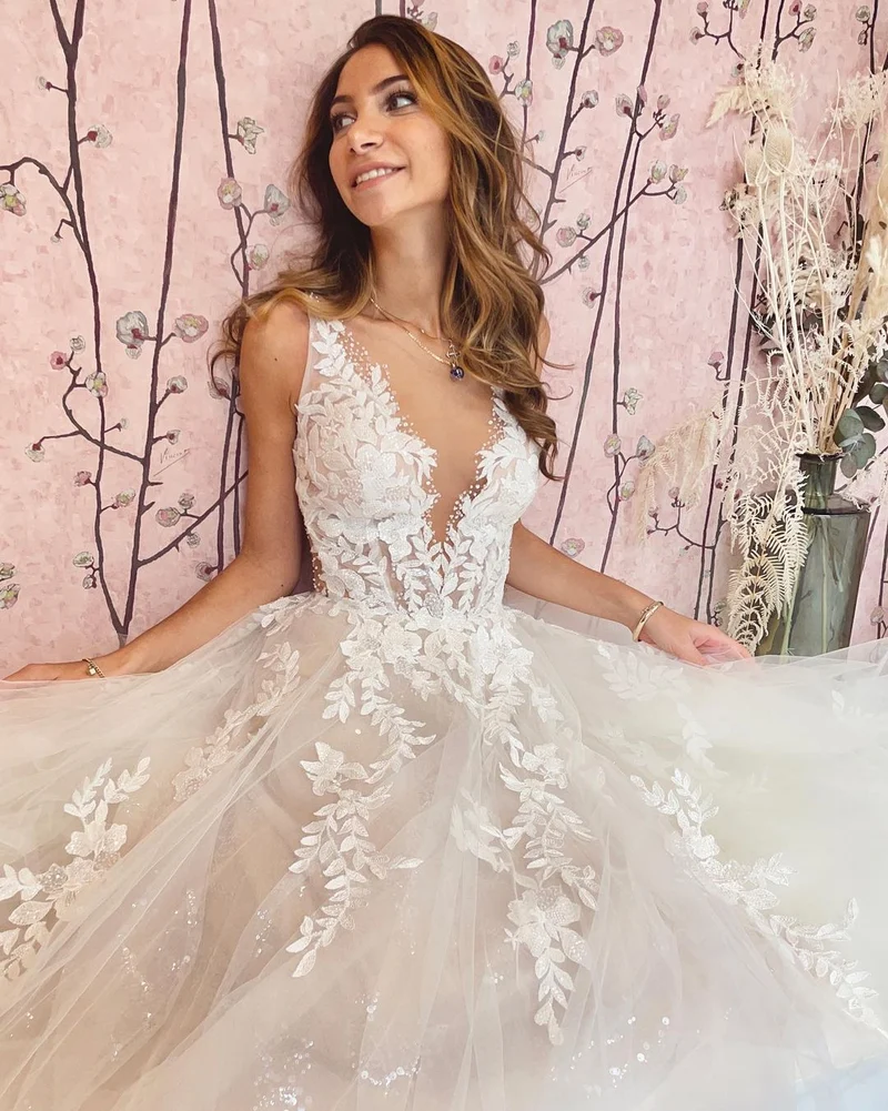 Robe de mariée élégante coupe trapèze, décolleté en V profond et dos nu, avec appliques en dentelle