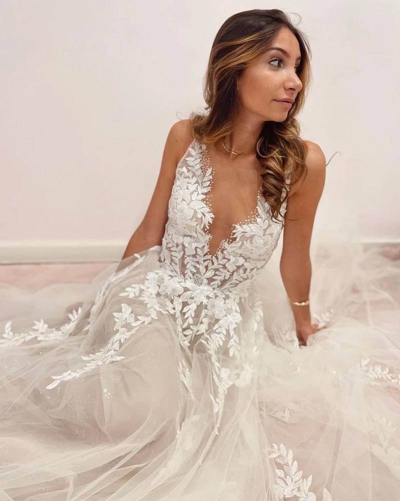 Robe de mariée élégante coupe trapèze, décolleté en V profond et dos nu, avec appliques en dentelle