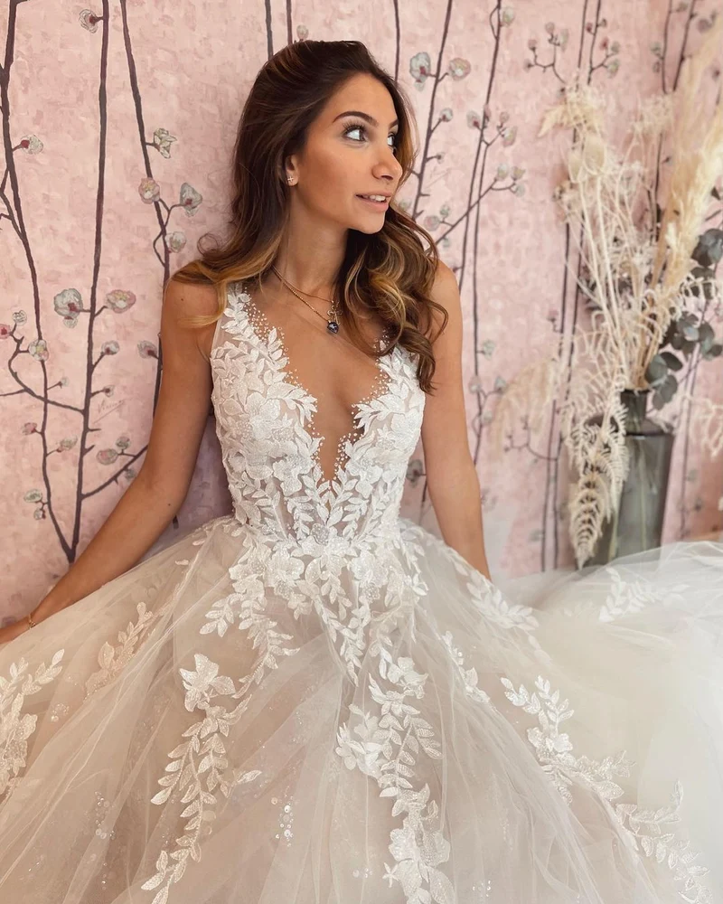 Robe de mariée élégante coupe trapèze, décolleté en V profond et dos nu, avec appliques en dentelle