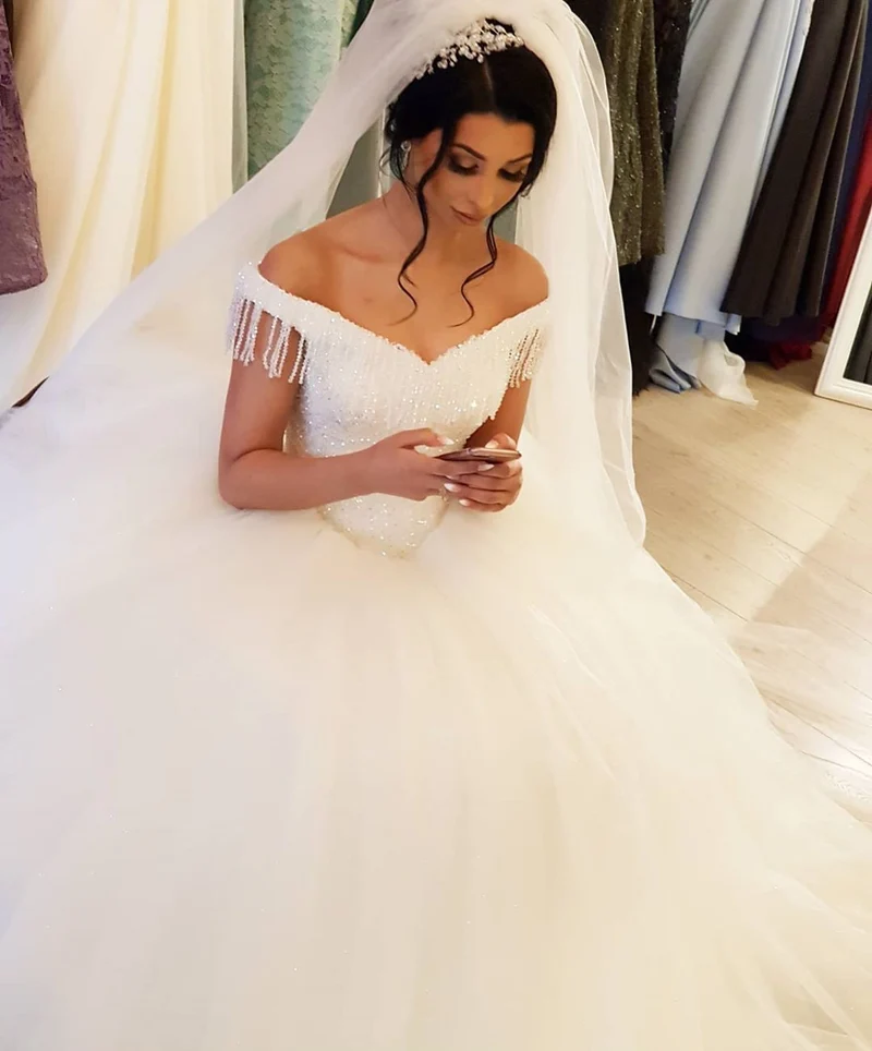 Superbe robe de mariée princesse en tulle à épaules dénudées et pompons perlés pour mariées