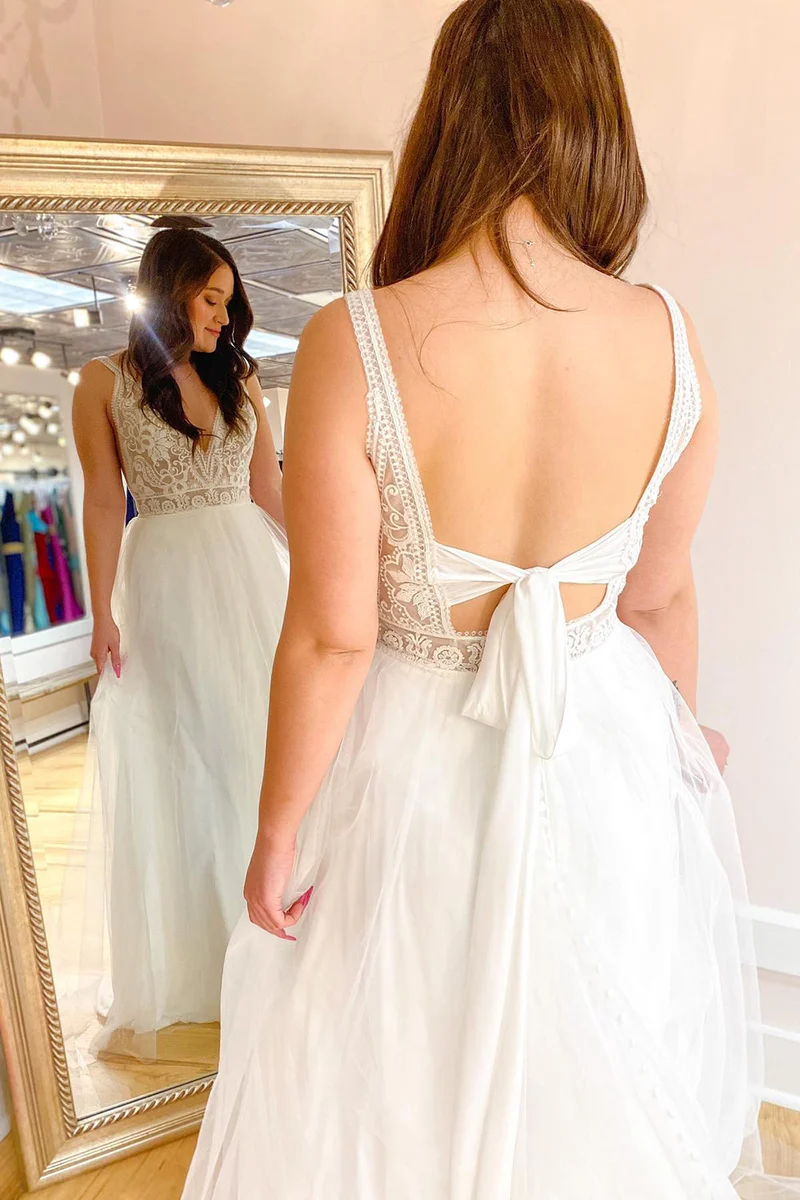 Robe de mariée élégante coupe trapèze : décolleté en V profond, bretelles spaghetti et traîne en tulle