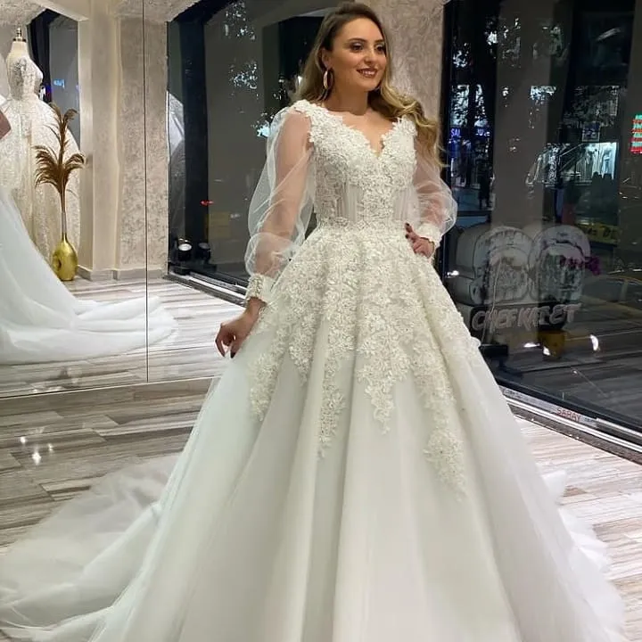 Robe de mariée trapèze à col en V avec appliques en dentelle et manches longues bouffantes