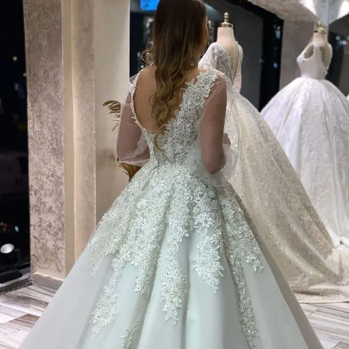 Robe de mariée trapèze à col en V avec appliques en dentelle et manches longues bouffantes