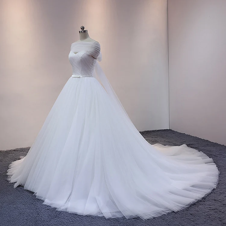 Robe de mariée princesse blanche en tulle avec traîne cathédrale et drapé sur les épaules dénudées