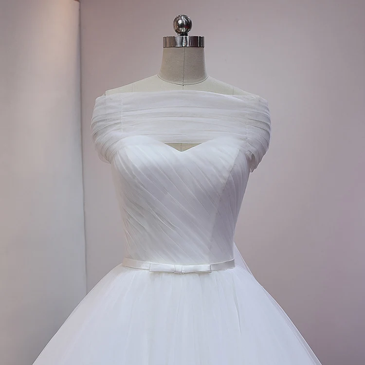 Robe de mariée princesse blanche en tulle avec traîne cathédrale et drapé sur les épaules dénudées