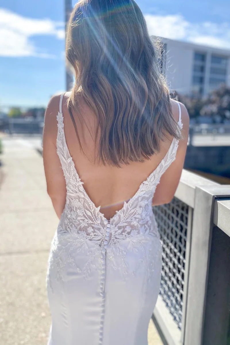 Robe de mariée sirène moderne : bretelles spaghetti, décolleté en cœur, dos nu, appliqués en dentelle