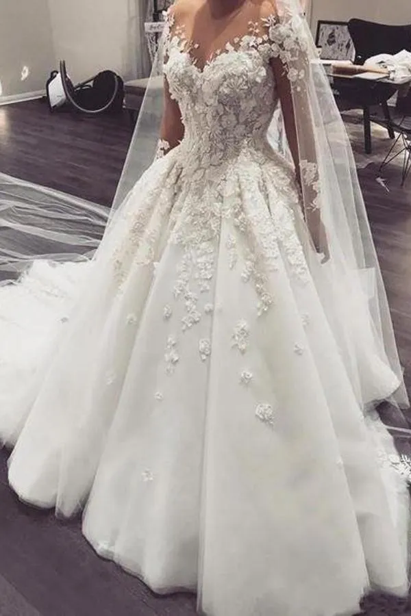 Robe de mariée élégante à manches longues et coupe trapèze, longueur au sol, avec de délicates appliques en dentelle.