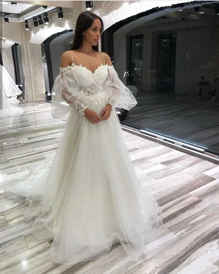 Robe de mariée élégante en tulle et dentelle, coupe trapèze, épaules dénudées, manches longues