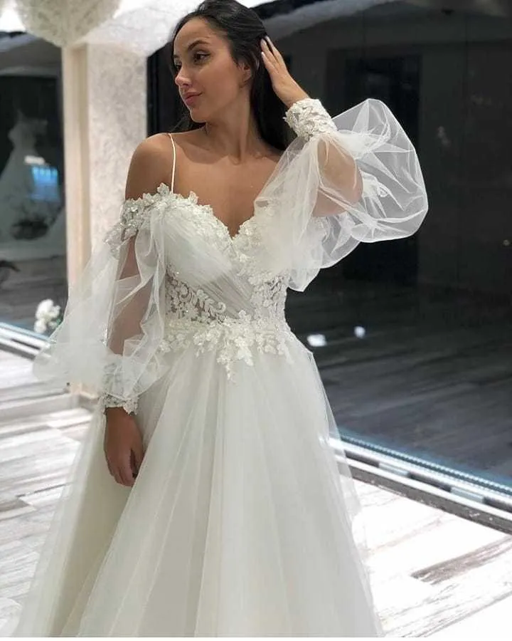 Robe de mariée élégante en tulle et dentelle, coupe trapèze, épaules dénudées, manches longues