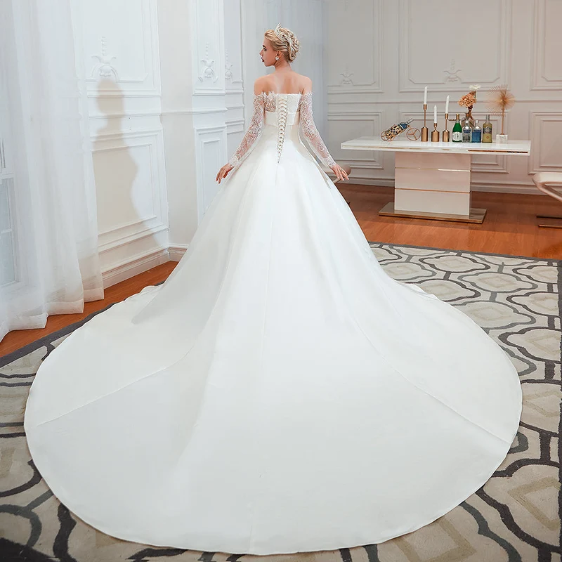 Robe de mariée élégante en satin à épaules dénudées et manches longues, coupe trapèze, avec dentelle délicate
