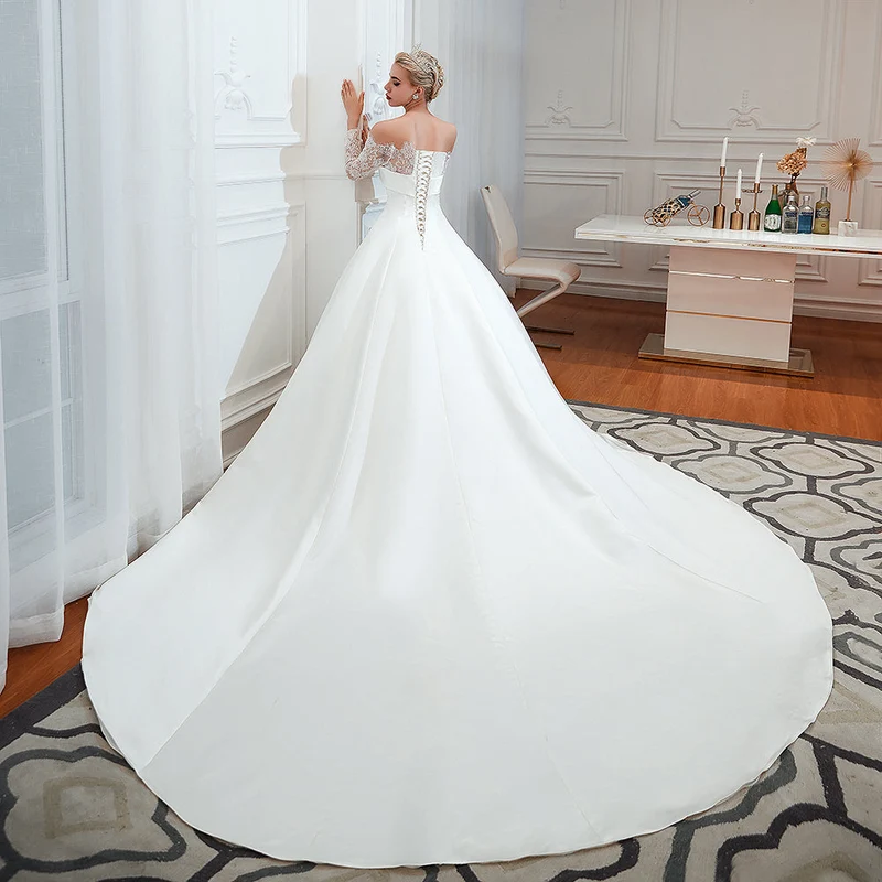 Robe de mariée élégante en satin à épaules dénudées et manches longues, coupe trapèze, avec dentelle délicate