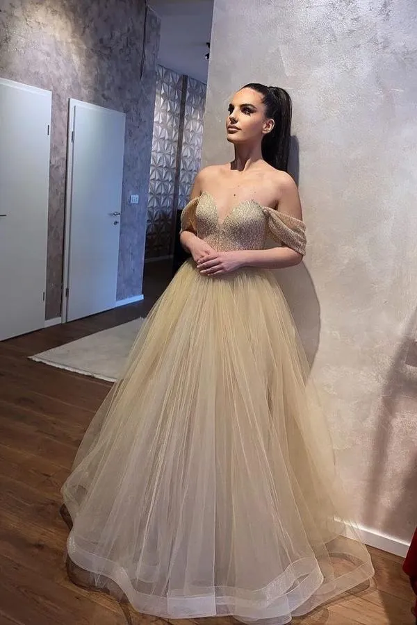 Robe de mariée élégante en tulle, décolleté en cœur, épaules dénudées, perles et coupe trapèze