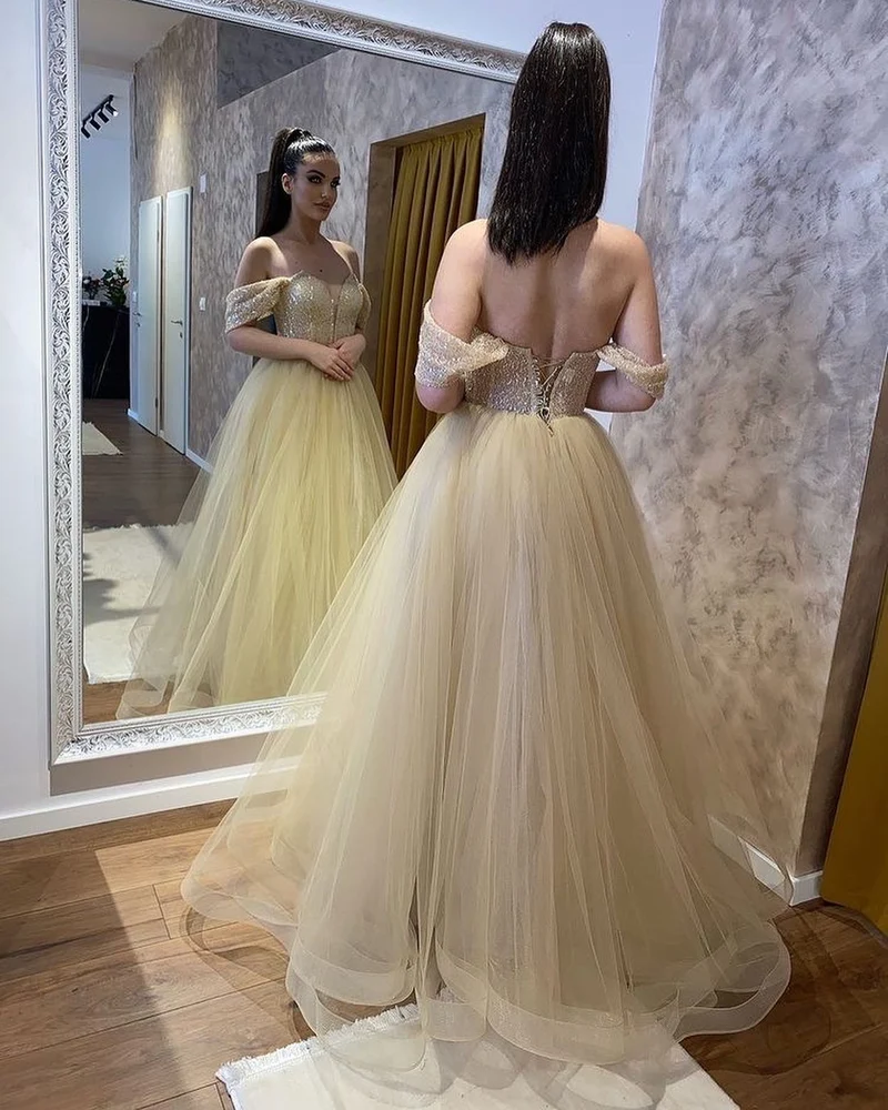 Robe de mariée élégante en tulle, décolleté en cœur, épaules dénudées, perles et coupe trapèze