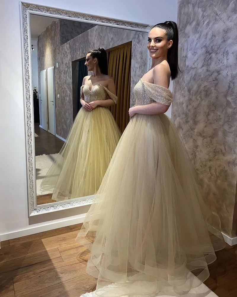 Robe de mariée élégante en tulle, décolleté en cœur, épaules dénudées, perles et coupe trapèze