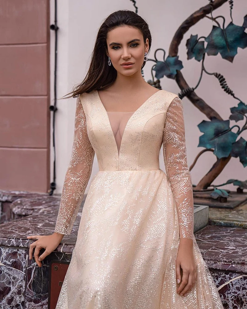 Robe de mariée scintillante à col en V et coupe trapèze, avec manches longues élégantes et détails pailletés