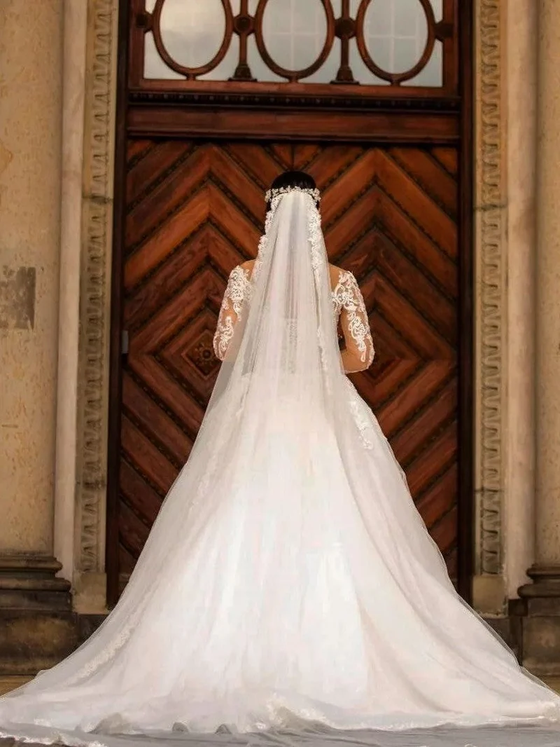 Robe de mariée élégante en dentelle, épaules dénudées, manches longues et traîne Watteau