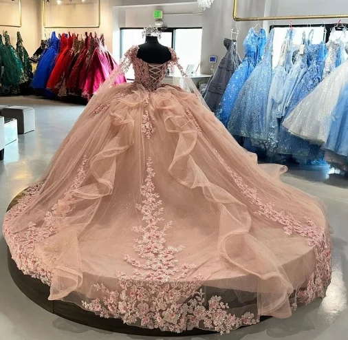 Robe de bal rose avec cape et détails floraux