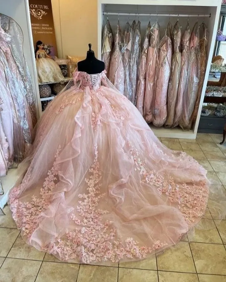 Robe de bal rose avec cape et détails floraux