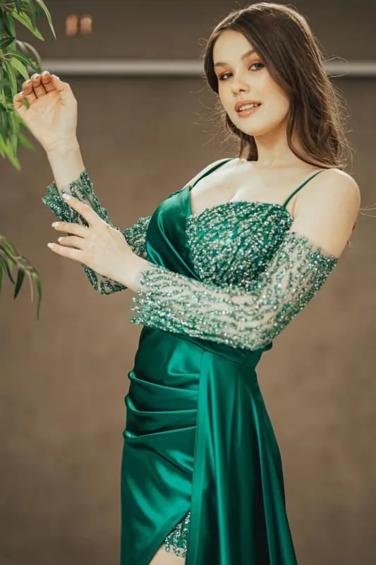 Robe de bal émeraude à bretelles spaghetti, épaules dénudées, paillettes et fente plissée