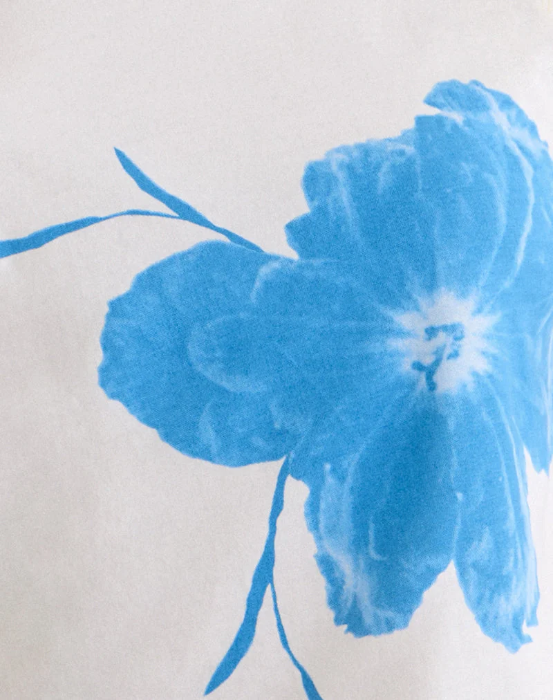 Haut asymétrique à manches courtes Balia, couleur blanc cassé, orné d'une silhouette de fleur bleue