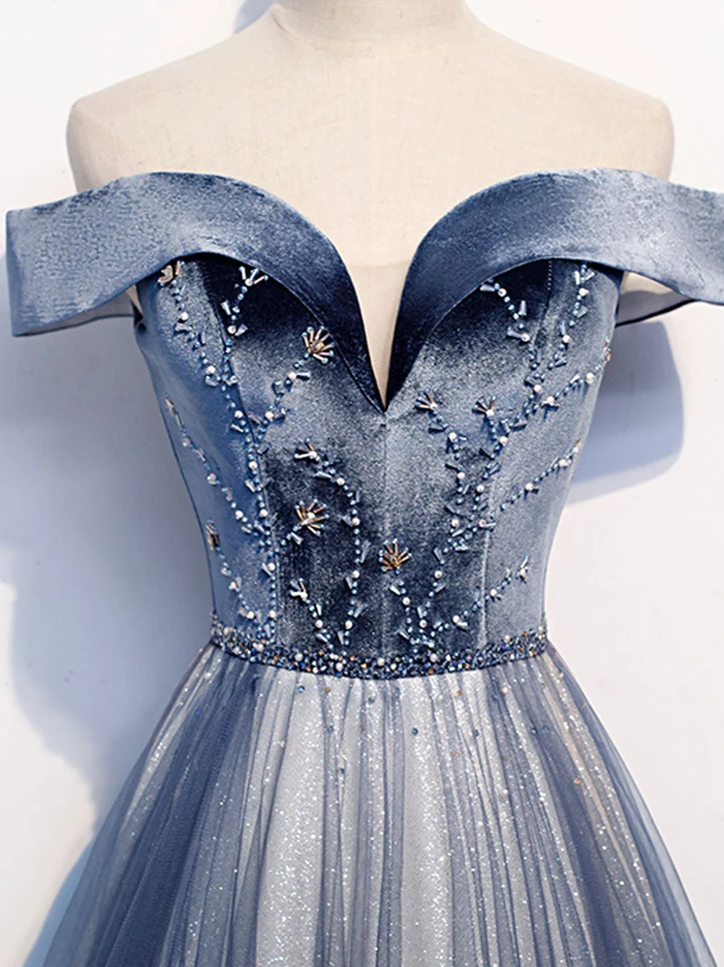 Robe de bal longue et élégante en tulle bleu, ornée de perles et de détails scintillants